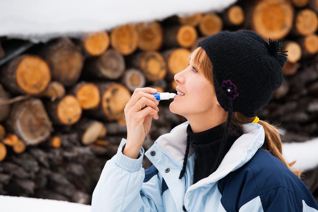 Woman applying sunscreen to her lips to avoid lip cancer