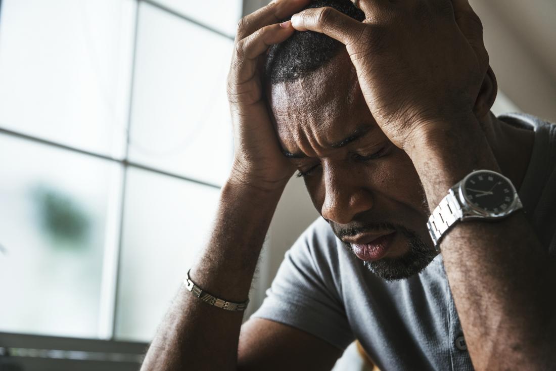 man holding his head in his hands, looking very stressed