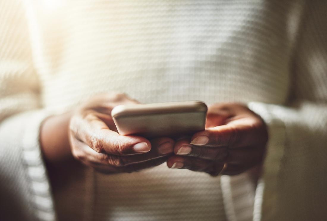 close up of a woman's hands holding a smartphone
