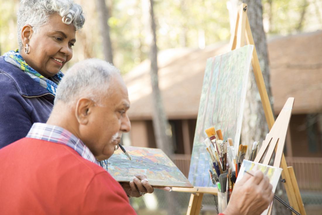Senior mature adults doing painting and art therapy outdoors