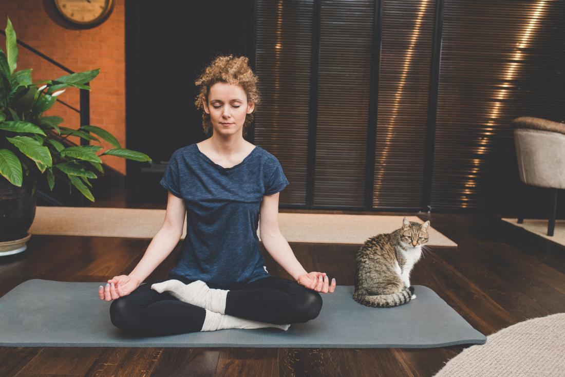 Woman meditating with cat