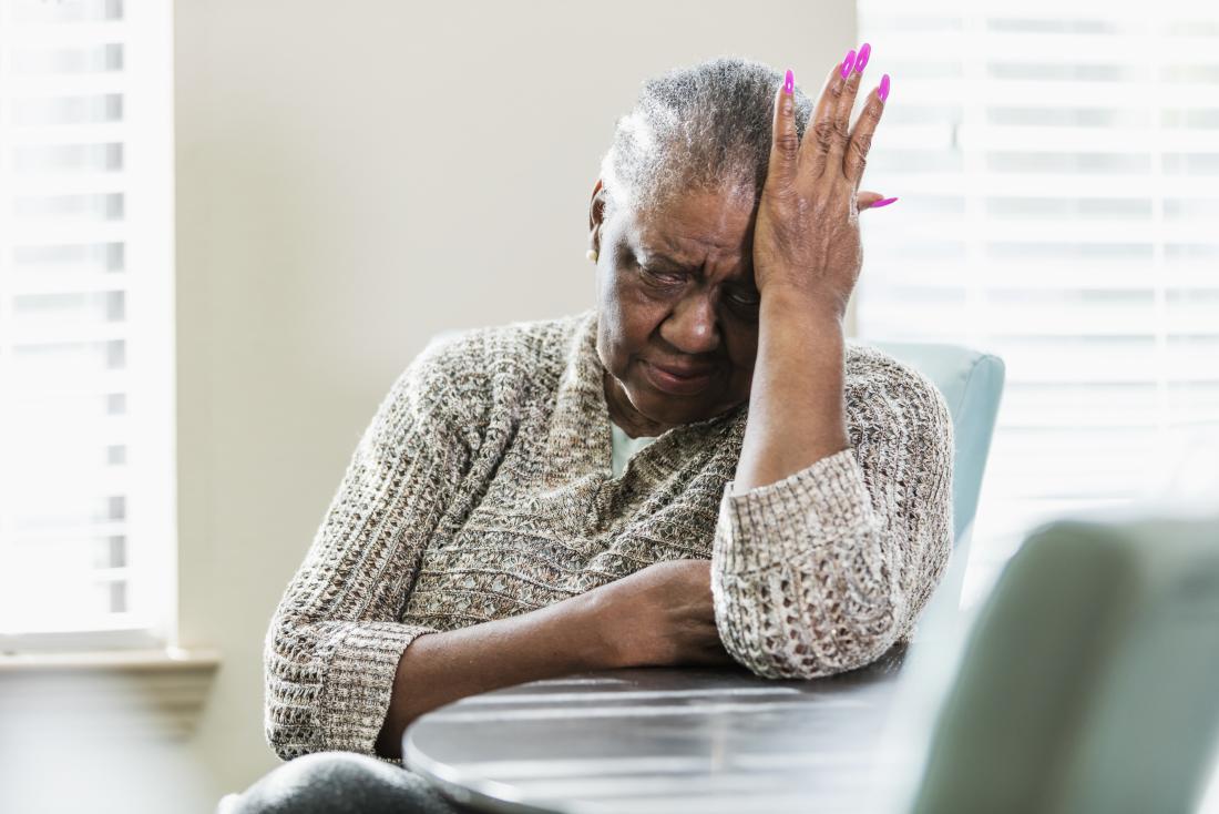 senior lady holding head in pain