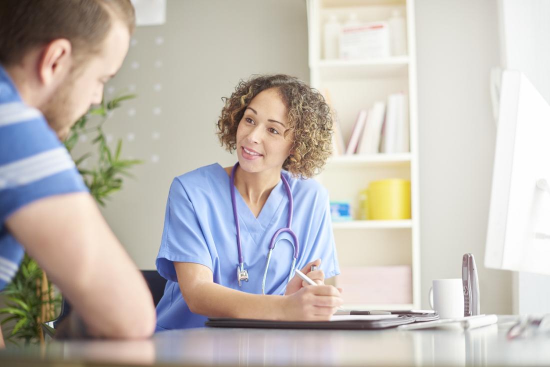 young doctor writing something out for a patient