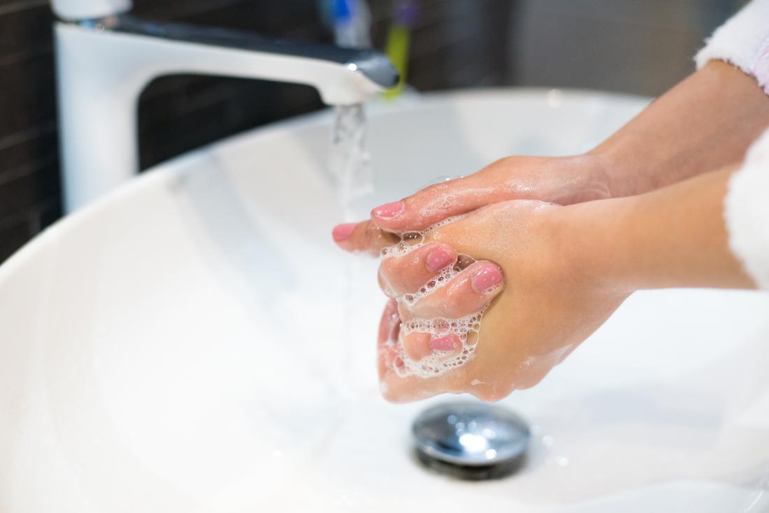 person washing their hands to remove germs
