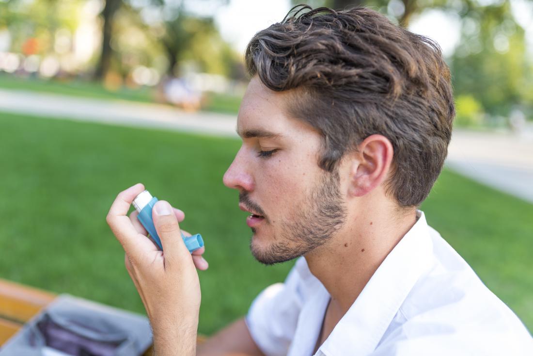 Man with asthma using inhaler.