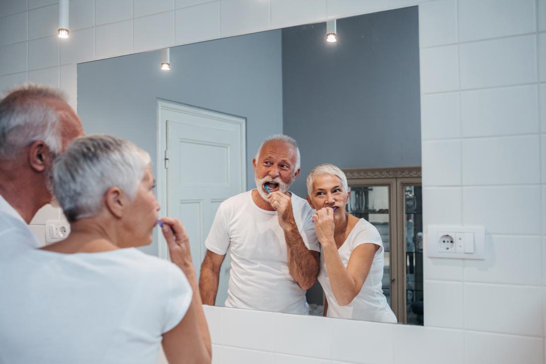 image of elderly couple brushing teeth together