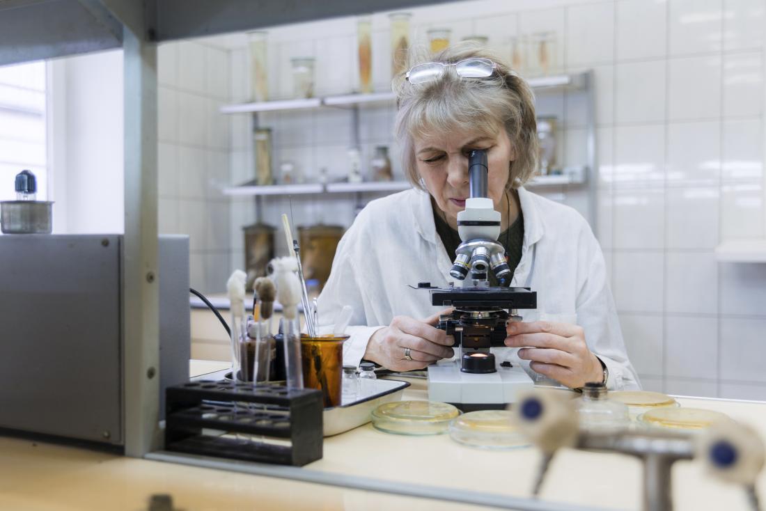researcher examining something through the microscope