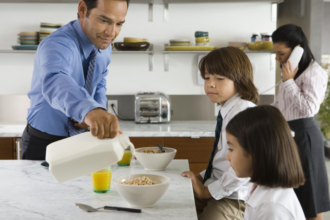 father pouring milk on to his childrens cereal