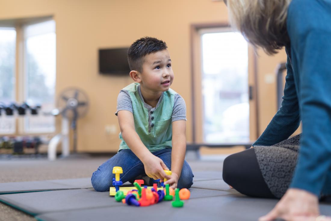 A therapist works with a young boy