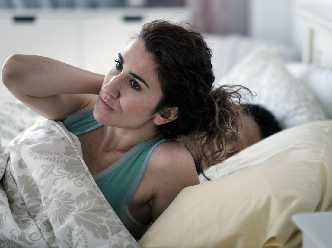 A woman waking up from a bad nights sleep.