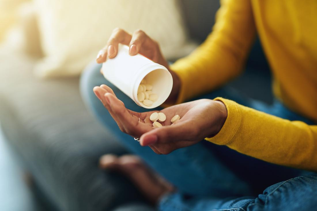 close up of woman's hands taking pills