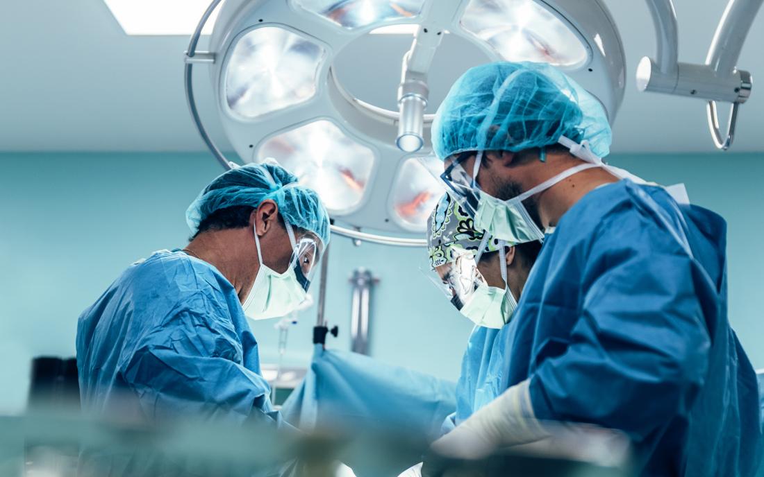 surgeons performing cystectomy or bladder removal surgery in operating theatre