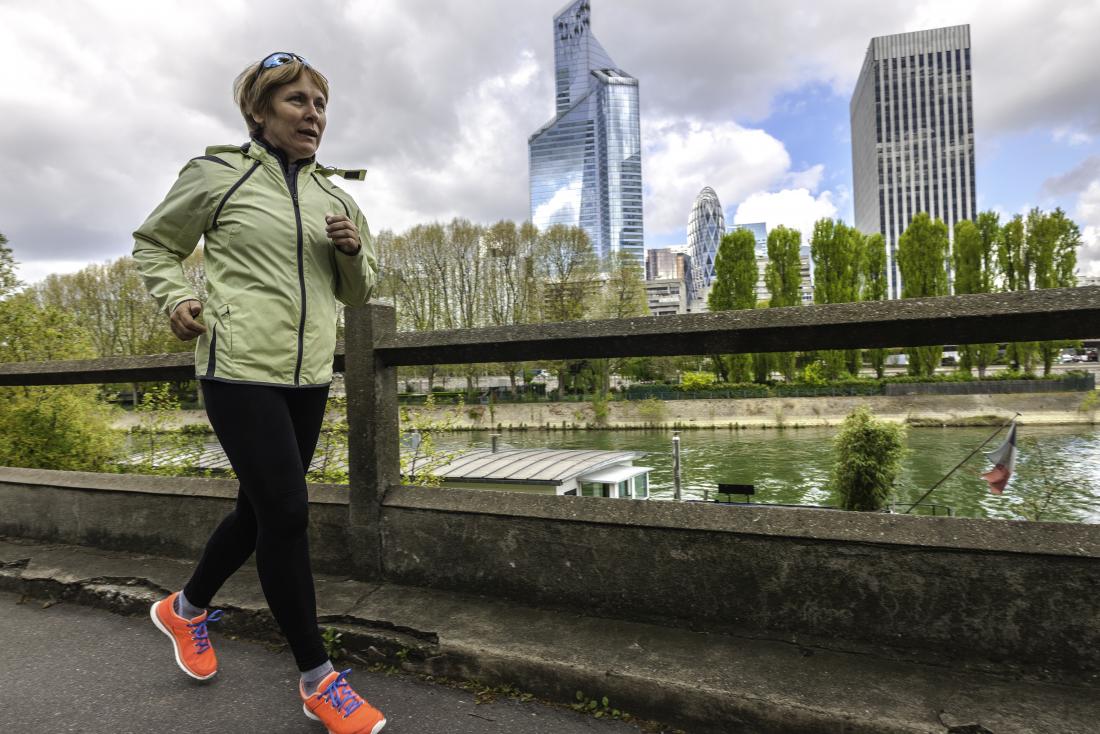 A woman going for a power walk through a busy city. 