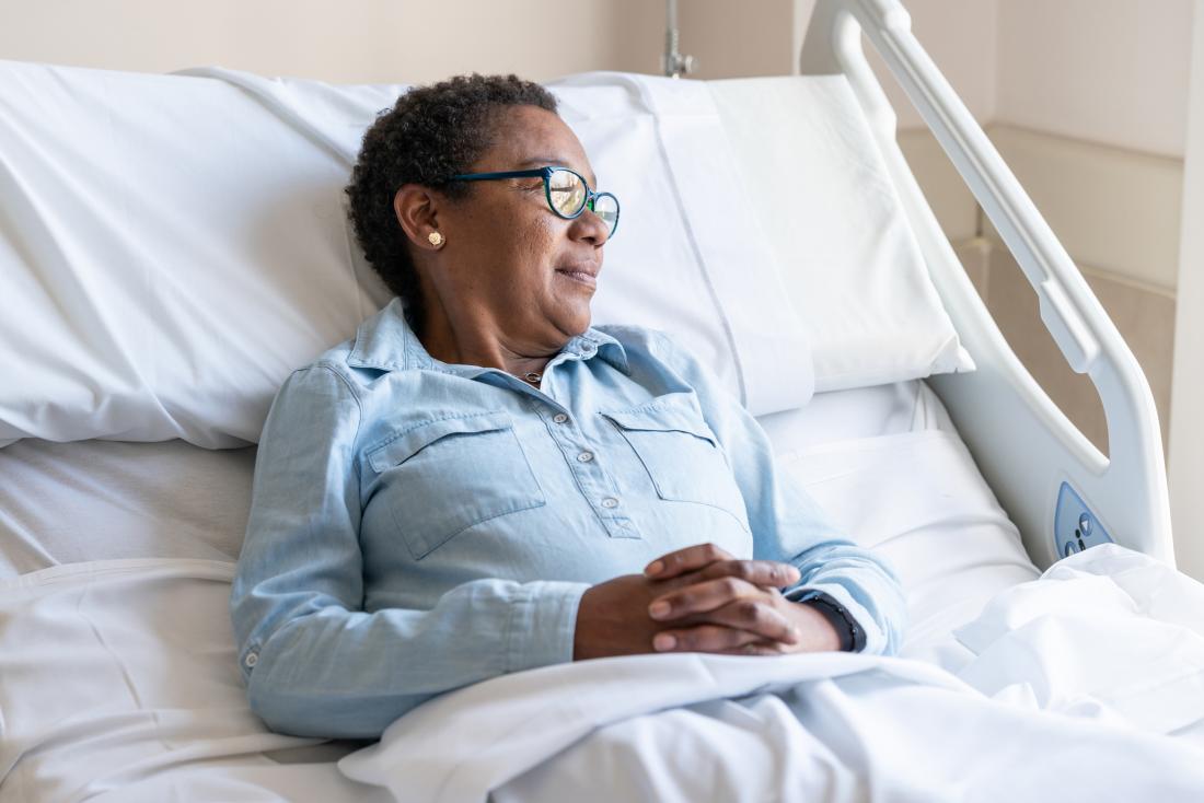 A woman of an older age in hospital waiting for breast cancer treatment.