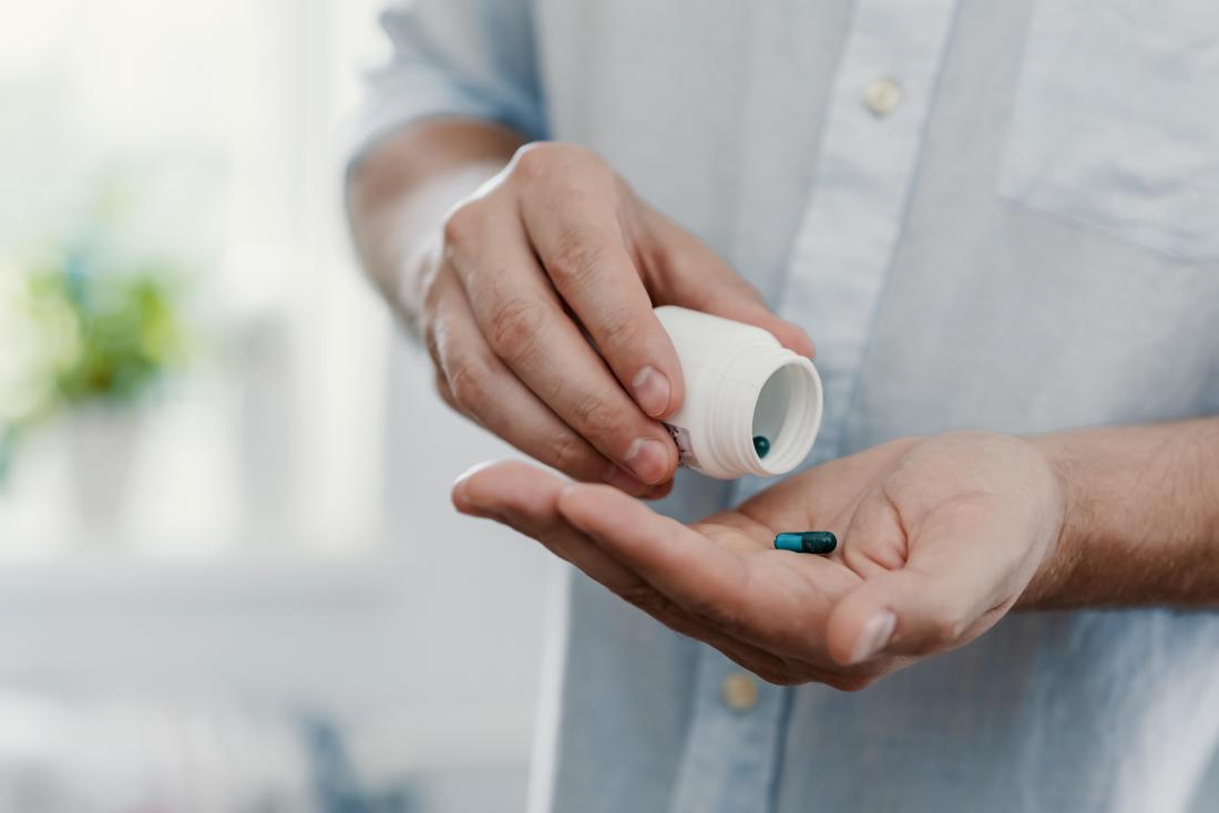man emptying capsule into hand