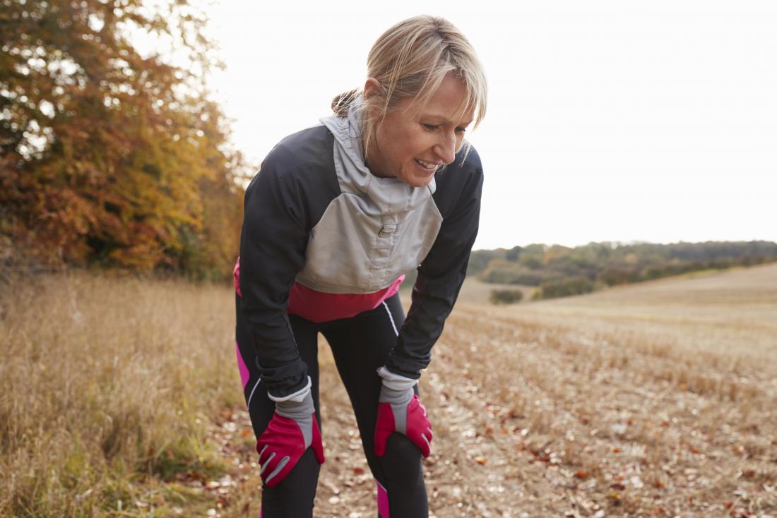 woman outdoors out of breath in running gear experiencing exercise induced asthma