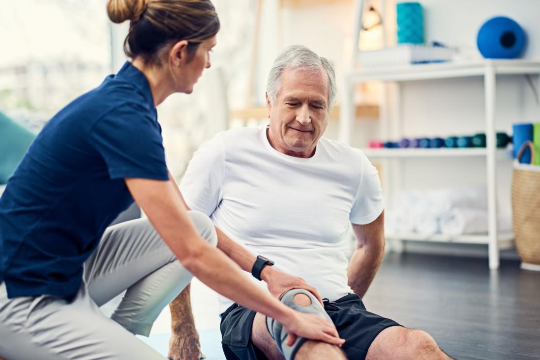 senior man with knee brace having physical therapy