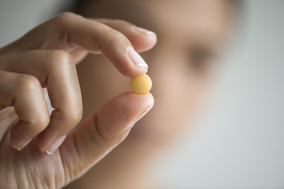 A Woman Holding A Pantoprazole Pill 