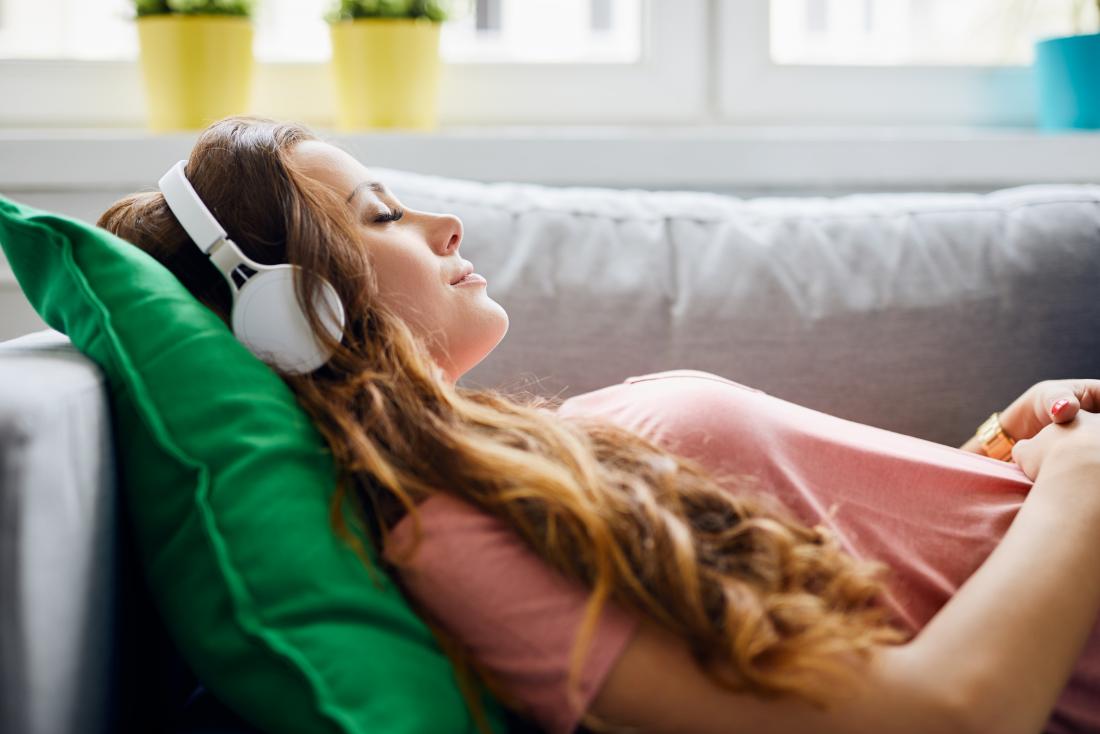 woman listening to relaxing music on a sofa