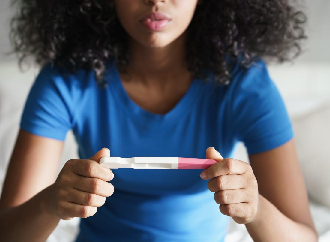 A woman with a pregnancy test wondering can you get pregnant from anal