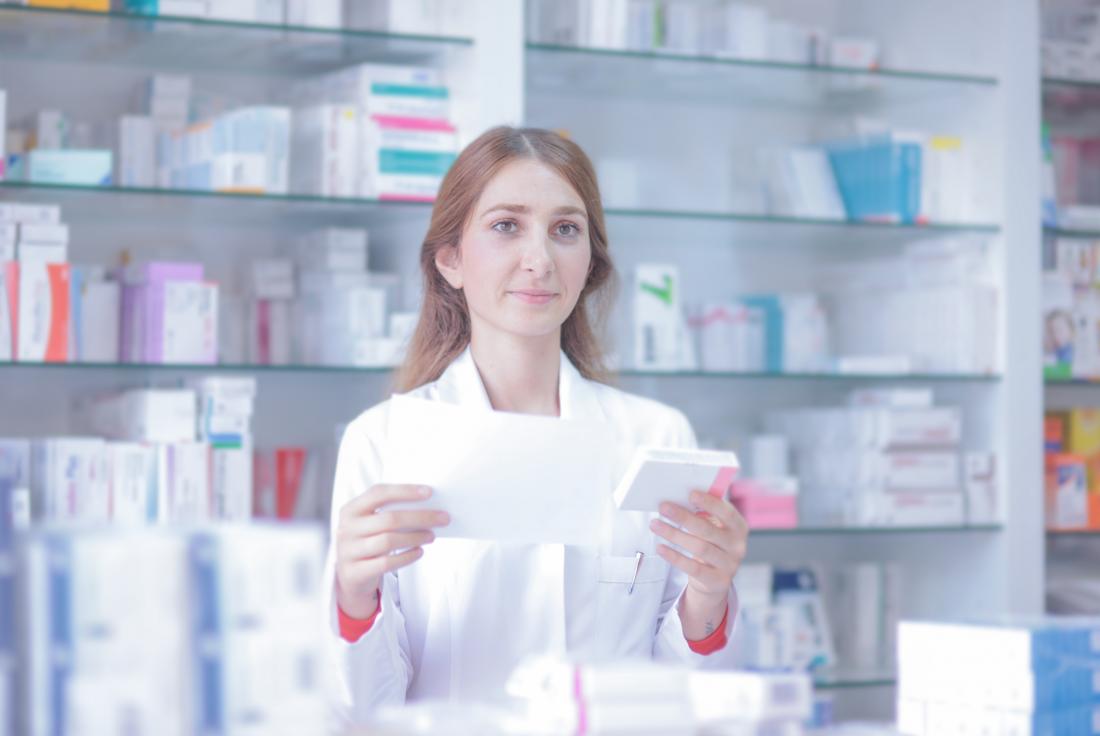 Pharmacist reading prescription andpreparing medicine