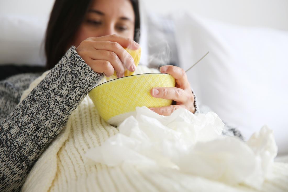 a woman drinking soup as a tonsillitis treatment at home