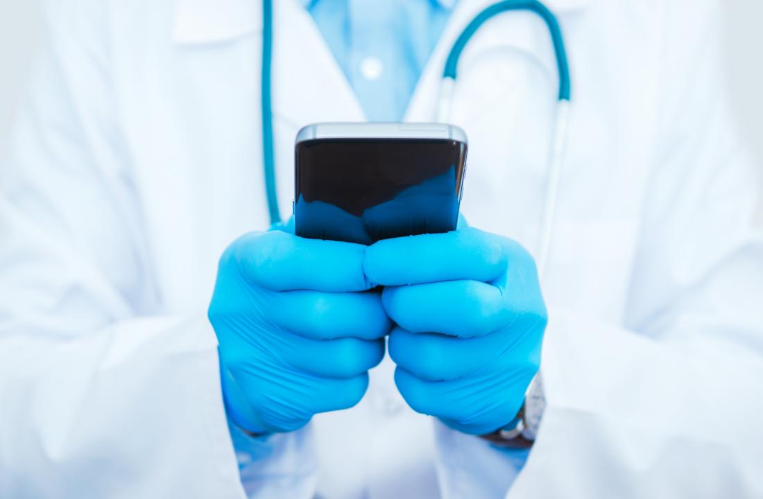 پزشکان دستکش را نگه داشتند که تلفن هوشمند دارند