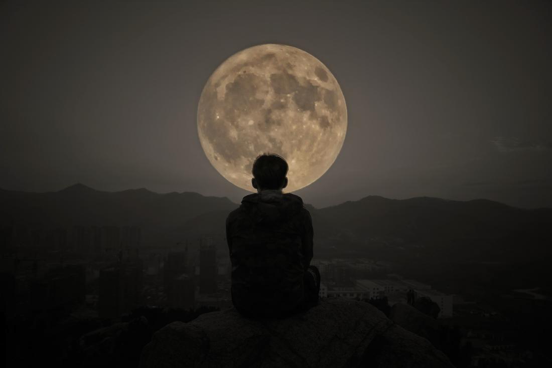 person looking at the full moon
