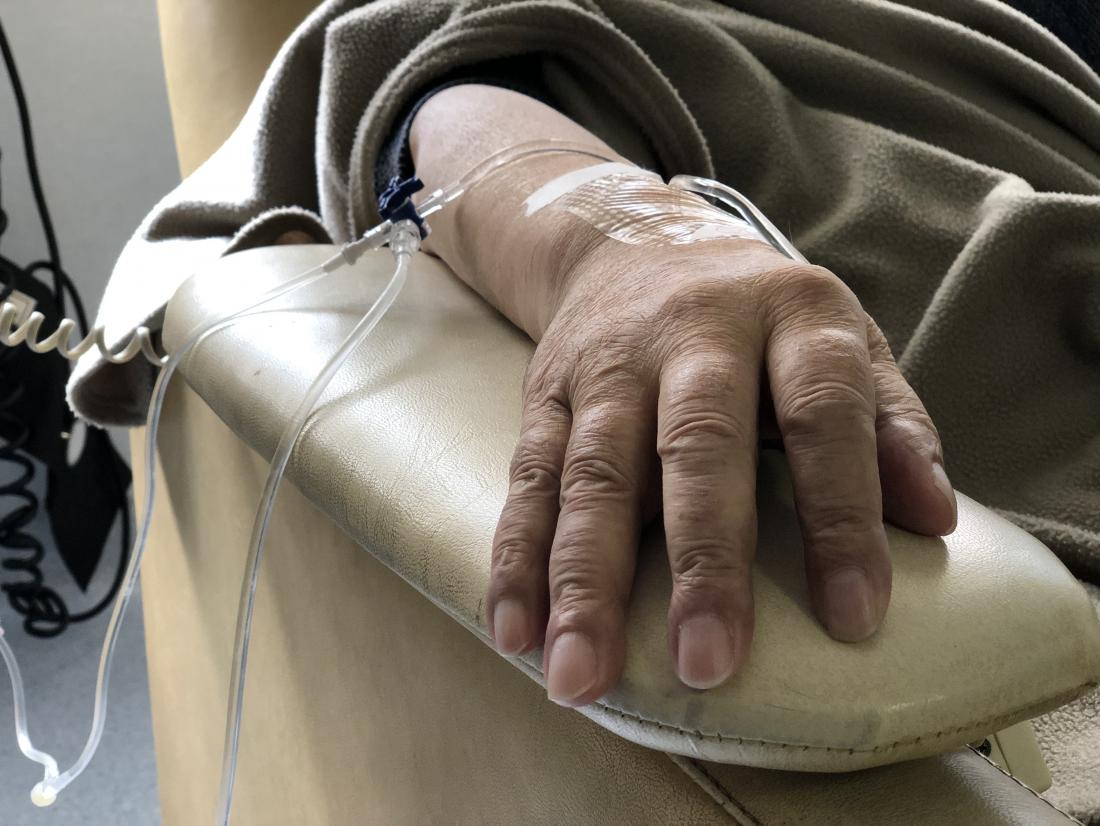 a mans hand who is receiving chemotherapy. 