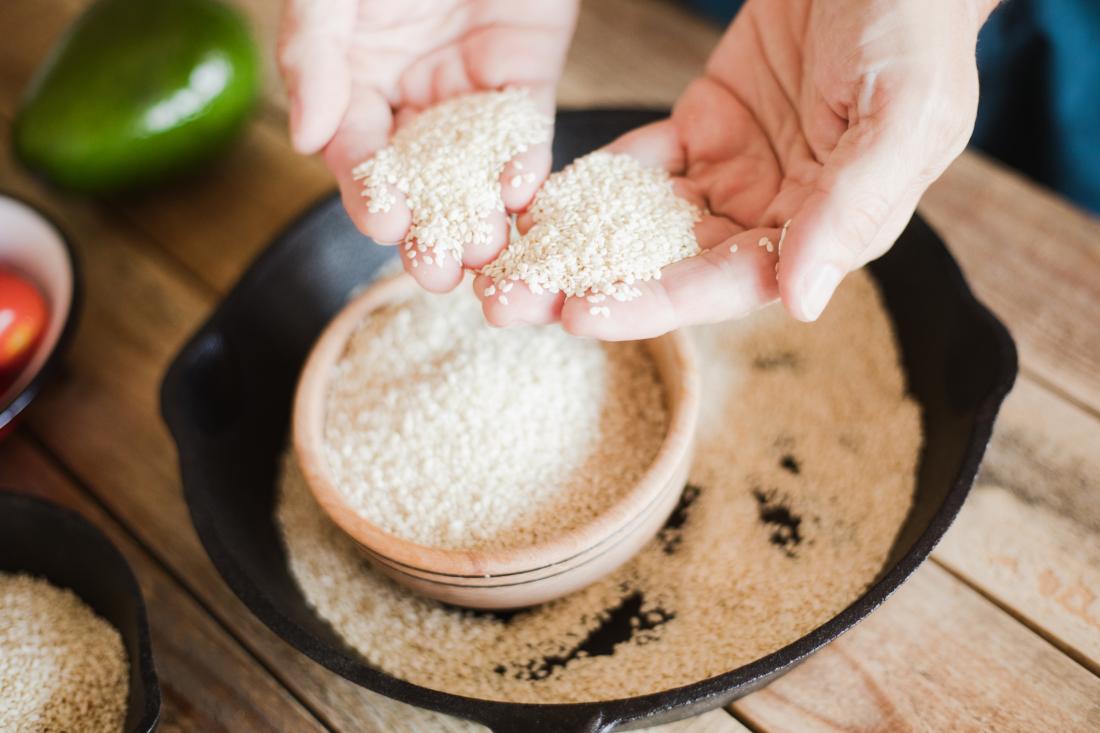 close up of hand holding sesame seeds