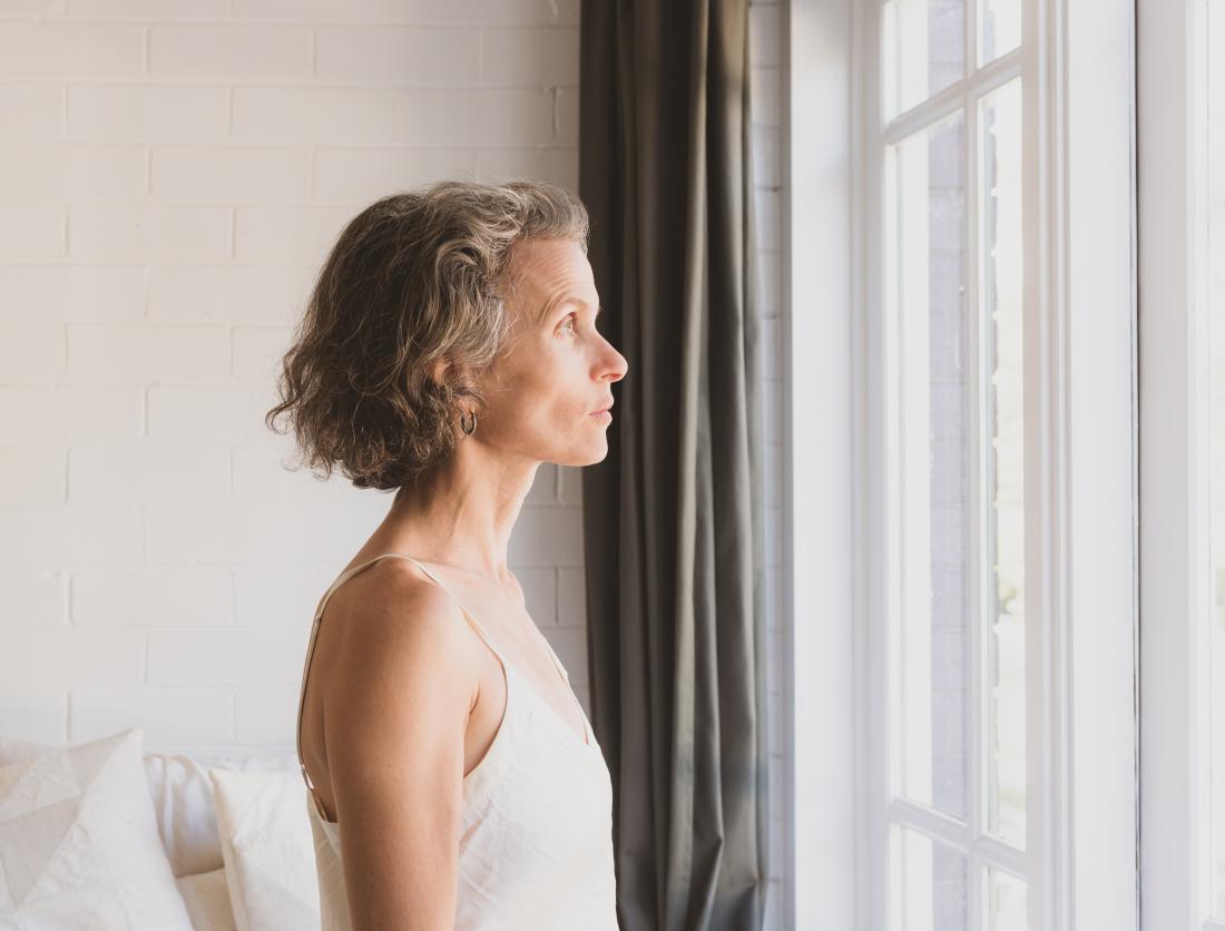 a woman looking out the window and contemplating her diagnosis of Her2 negative breast cancer