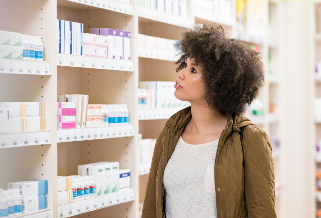 a woman browsing the shelves in a pharmacy.