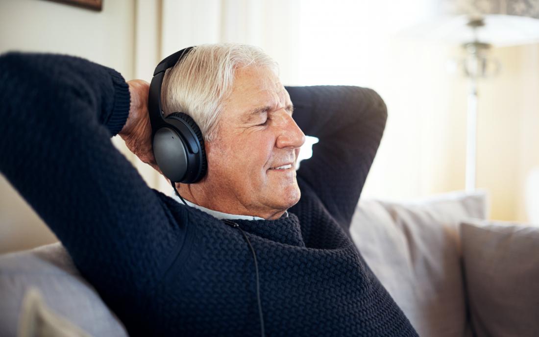 a senior man listening to music on headphones