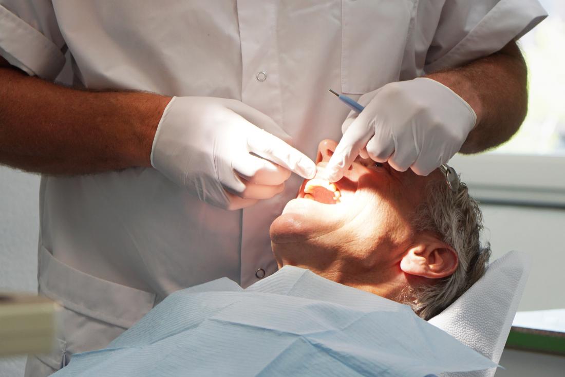 a man getting his teeth checked by his dentist