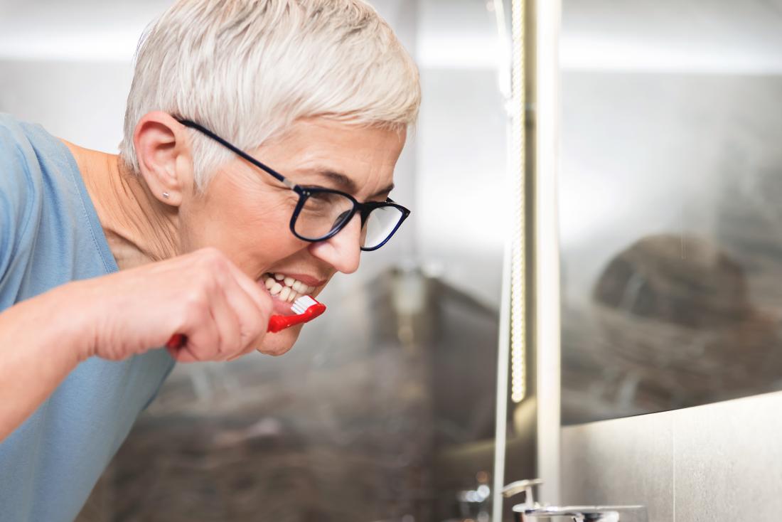 A woman brushing her teeth with Hydrogen peroxide for teeth whitening