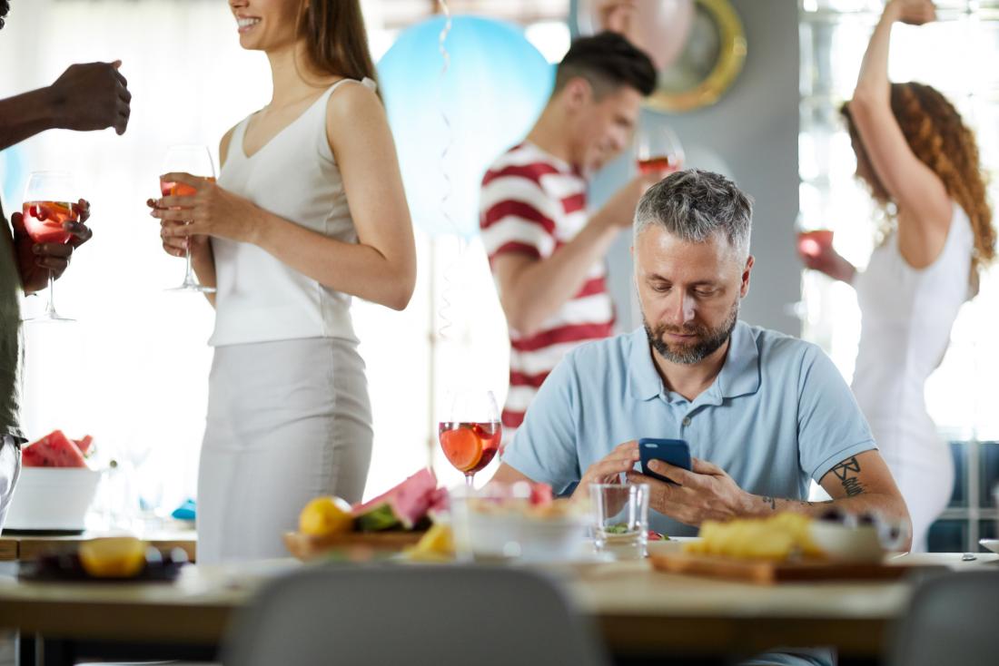 man checking his phone at party