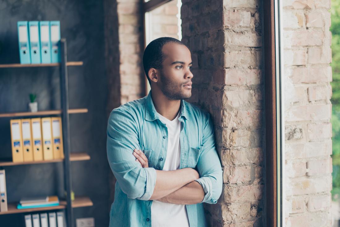 a man looking out a window and thinking about his Eating disorders