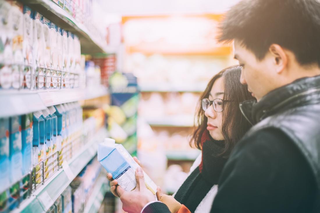 Casal comprando leite e se perguntando se o leite é ruim para você