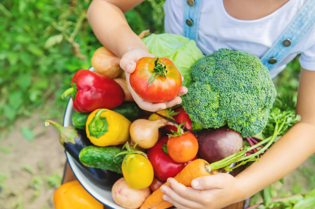 child holding fresh vegetables for hyperthyroidism diet