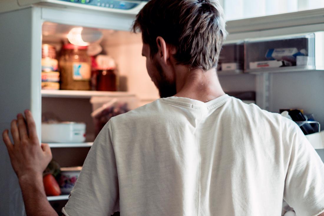 a man looking in his fridge wondering the benefits of keto vs paleo