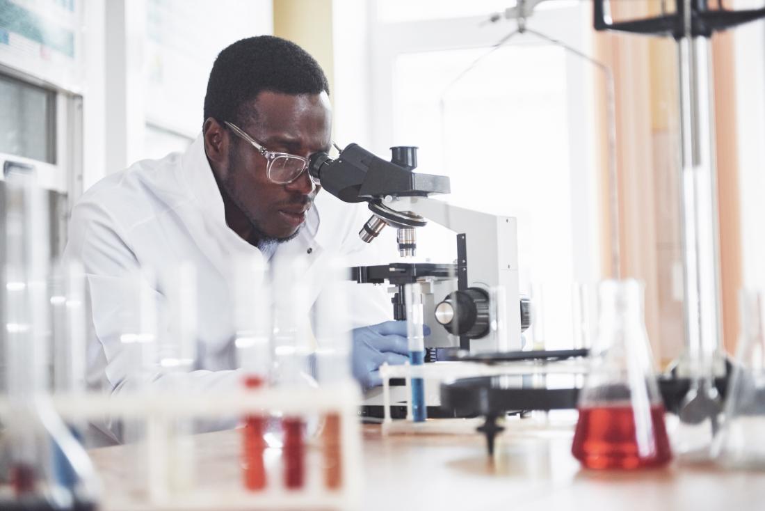 scientist looking through a microscope