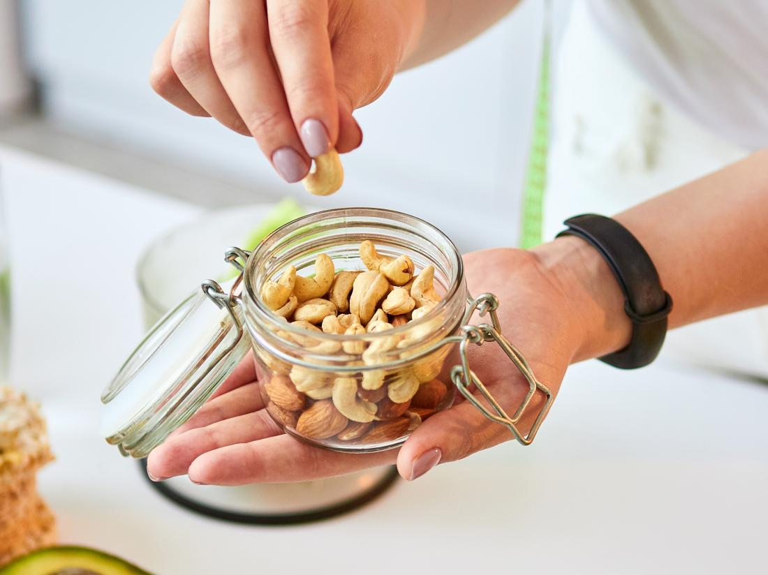 a woman about to eat nuts as part of her keto diet to lower cholesterol