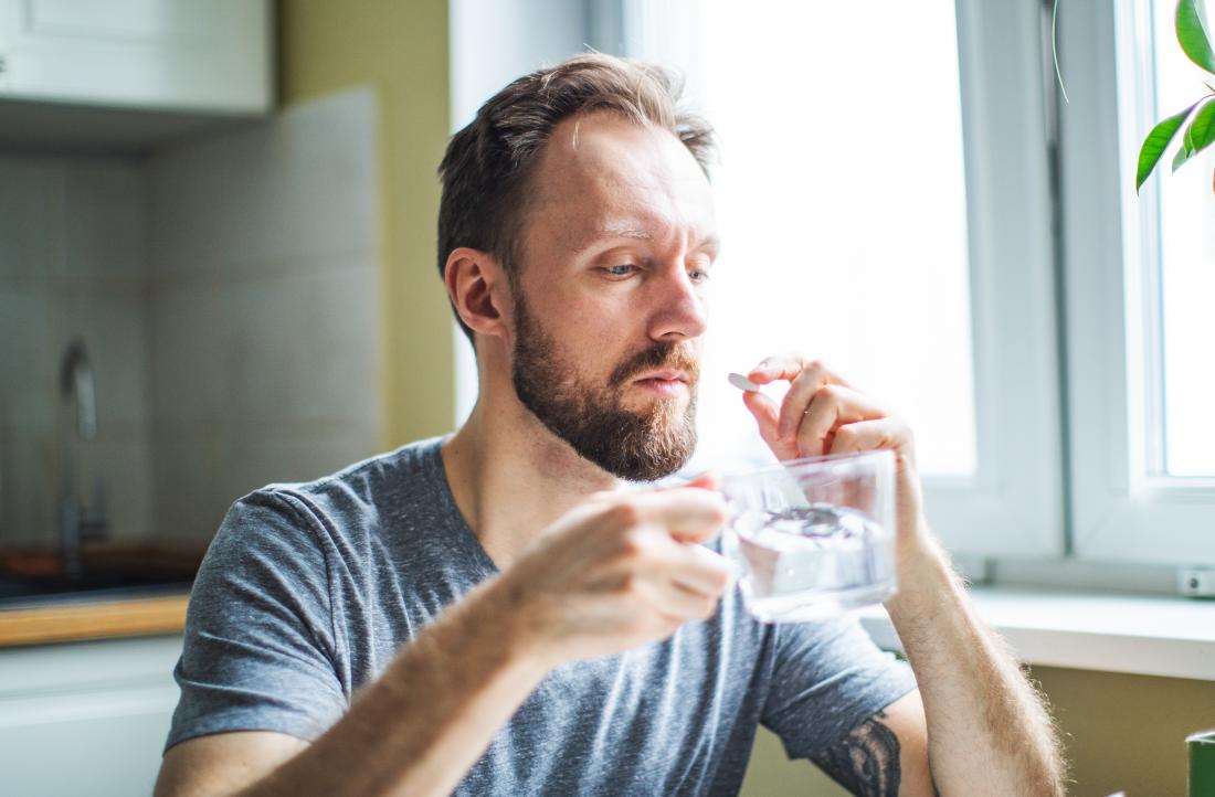 a man taking his medication in the morning