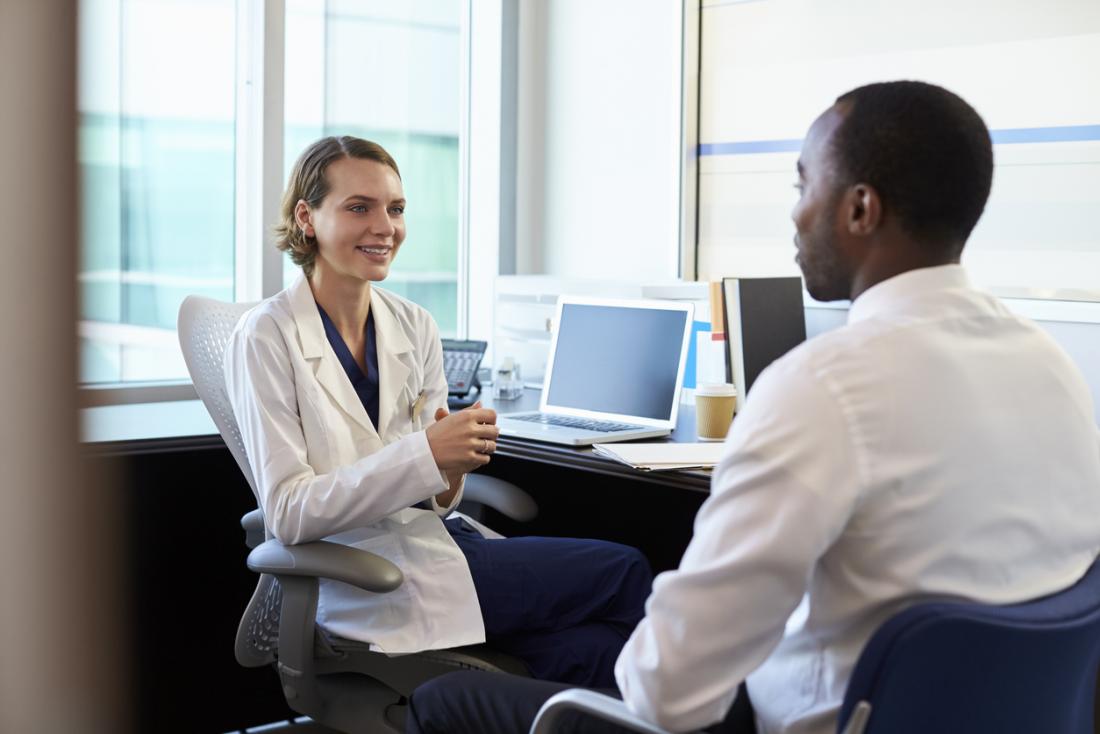 young male patient speaking with female doctor in her office