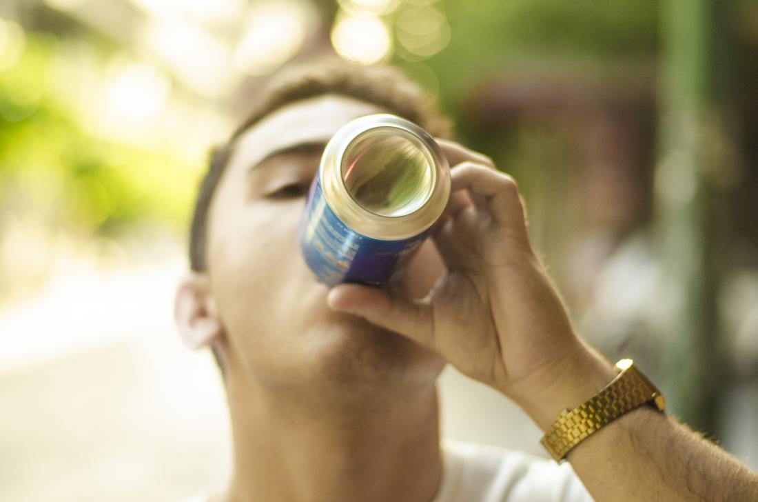 a man drinking out of a can 