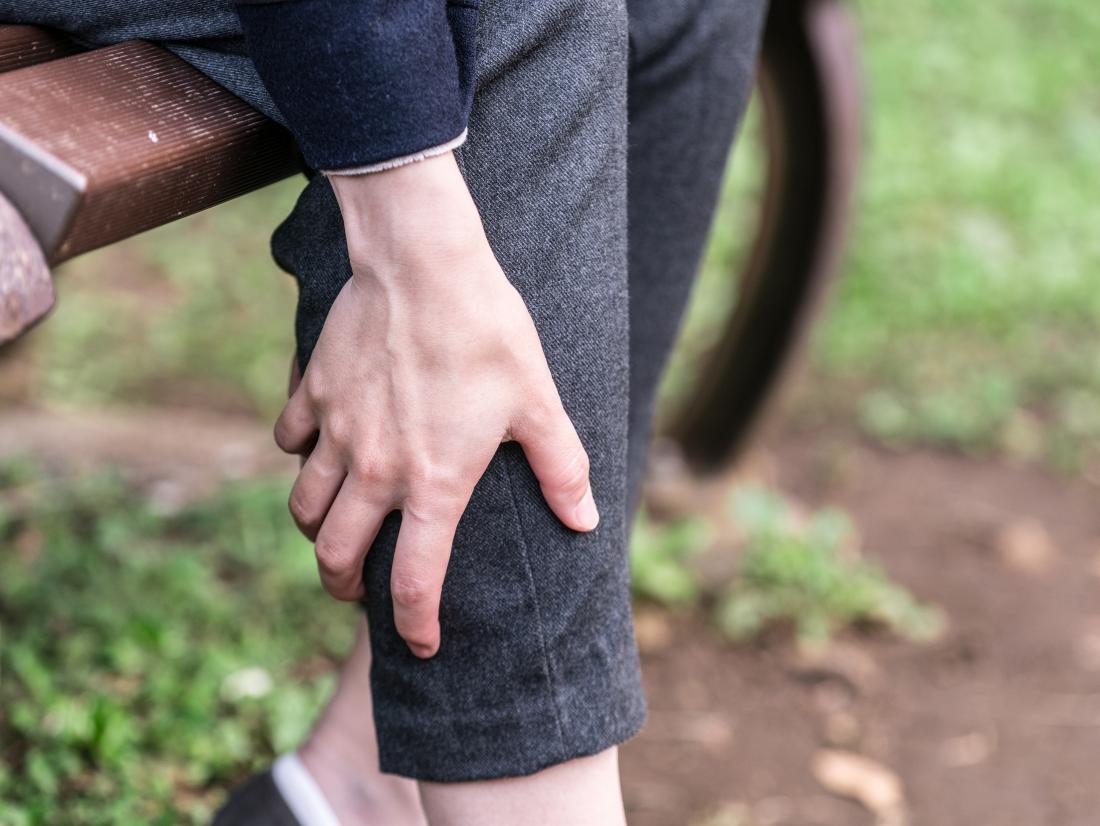 a woman with itchy legs sat in the park. 