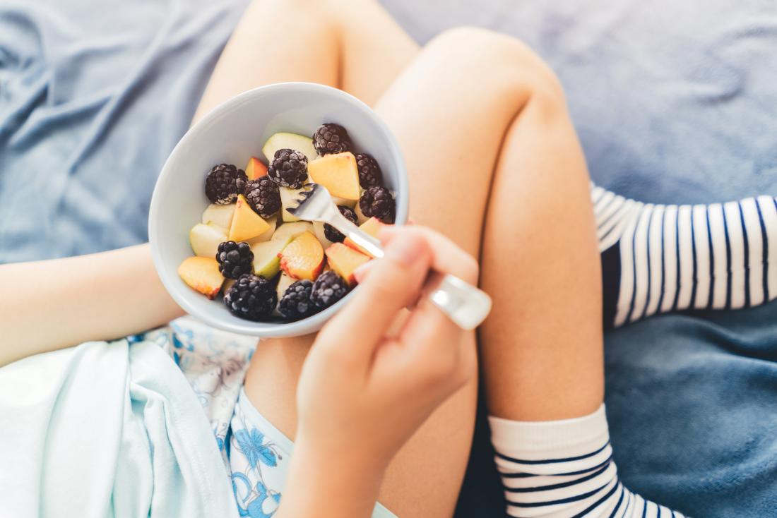 woman eats fruit salad