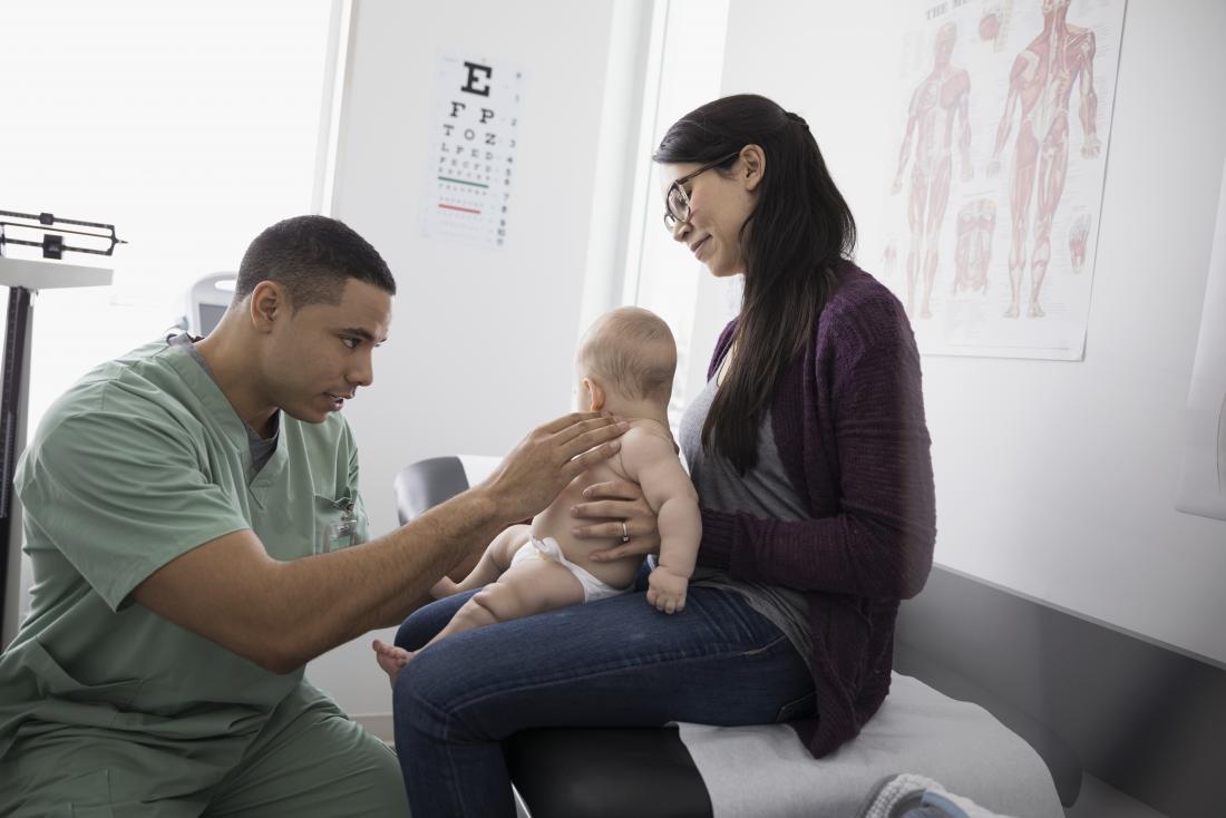 doctor with baby and mother in pediatrician office