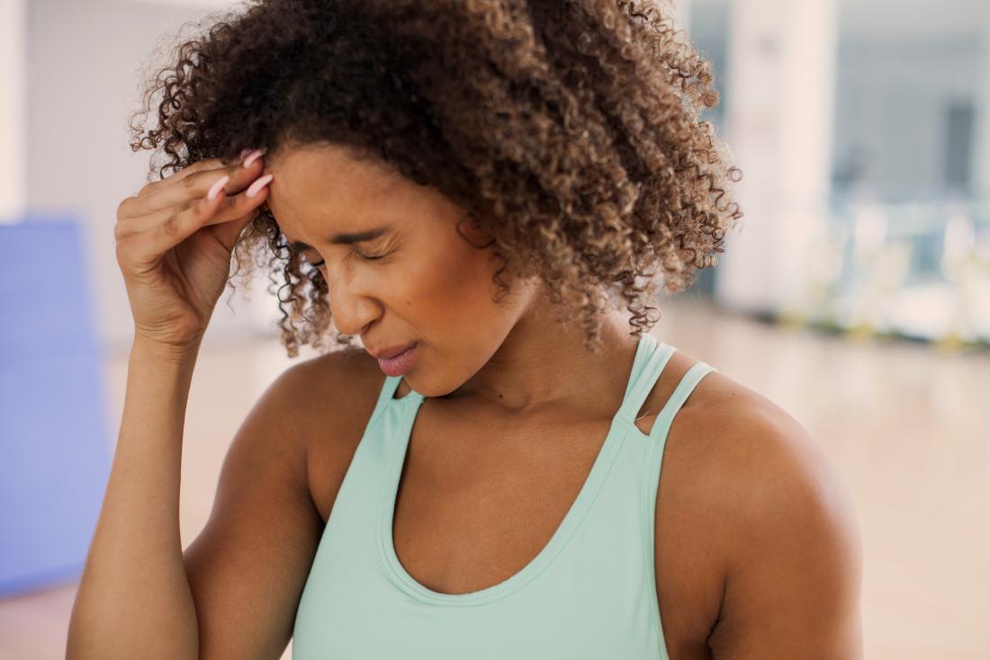 a woman experiencing a headache during exercise