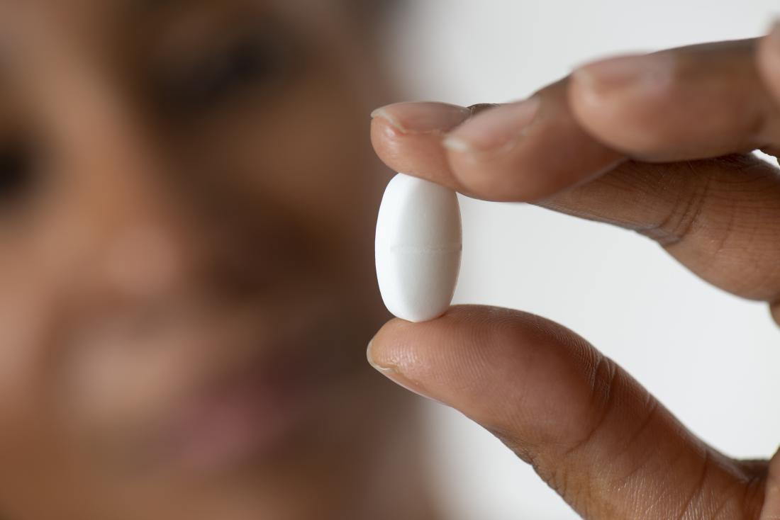 close up of woman holding white pill